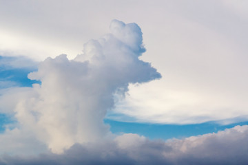 Beautiful cumulus clouds of unusual shape in the blue sky on a summer day