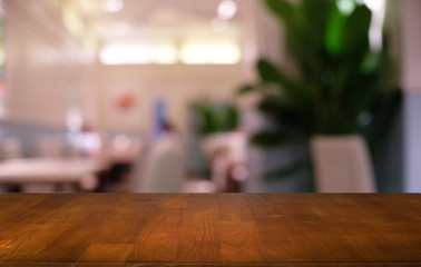 Empty dark wooden table in front of abstract blurred bokeh background of restaurant . can be used for display or montage your products.Mock up for space.
