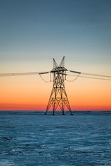 Electrical tower on a prairie winter dawn in January