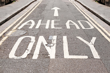 Ahead only signage imprint on a tarmac road.