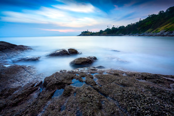 Sea and boulders foreground with long exposure shot when dusk. Shot at Yanui Beach, Phuket, Thailand.