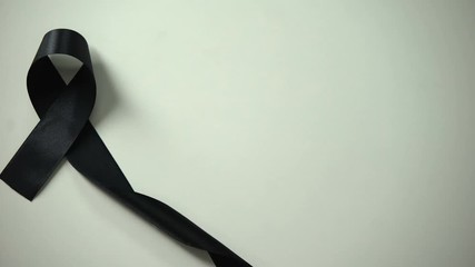 Black ribbon on table, melanoma awareness month skin cancer treatment prevention