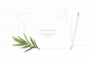 Flat lay top view elegant white composition paper envelope pencil tarragon leaf on wooden background