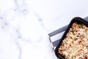 Delicious fried rice in lunch box with napery on marble background for ready to eat and food concept