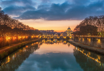 Fototapeta premium Rome (Italy) - The Tiber river and the monumental Lungotevere at sunset. Here in particular the Saint Peter basilica in Vatican
