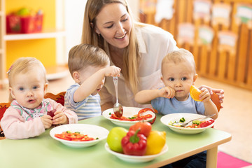 Children with teacher playing educational toys, stacking and arranging colorful pieces. Learning...