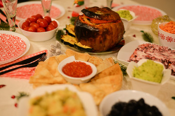 Food table :  traditional Russian food for new years eve ,red caviar with  blintzes crepes , pumpkin with rice , traditional Russian salad  - Herring under a fur coat - shuba , salted cherry tomatoes