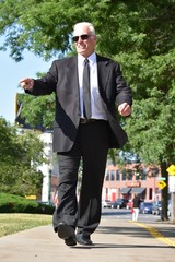 Adult Senior Politician Pointing Wearing Tie Walking On Sidewalk
