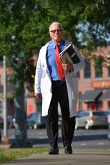 Handsome Senior Male Doctor Smiling Walking