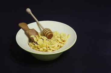 Corn flakes in a plate. Breakfast from flakes with honey and milk. Fast breakfast with corn flakes.
