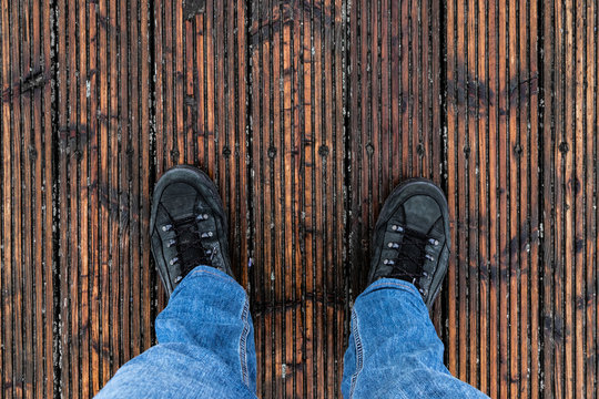 Person in Jeans steht auf Holzboden