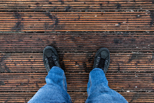 Person in Jeans steht auf Holzboden