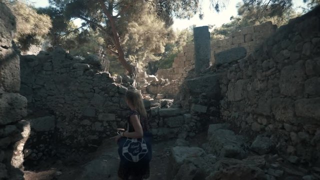 Beautyful Woman Walk And Shoot From Mobile In Ancient Town.Young Woman Using Smartphone While Exploring Antique City.Woman In A Dress Walks Along The Ancient Town.Woman Walking In Greek Ancient City. 