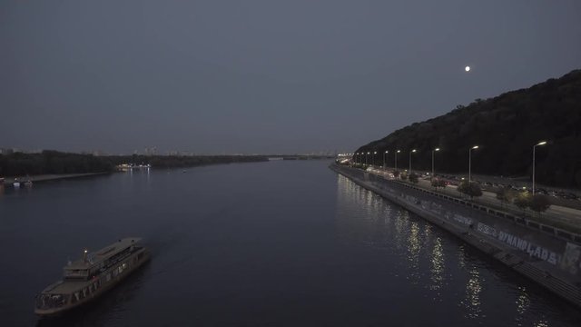 Dniper.Ship Sails On The River At Sunset. Boat Float On Dniepr River at winter Sunset. Cargo Ship Sails On The Horizon Over The Calm Lake.Cargo Ship Sails On The River At Sunset.