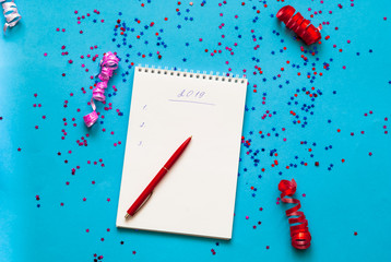 Wishes for the new year. Note book on blue background with sparkles. Planning concept.  