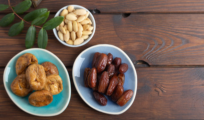 Dried figs and dates on a platter on a wooden table