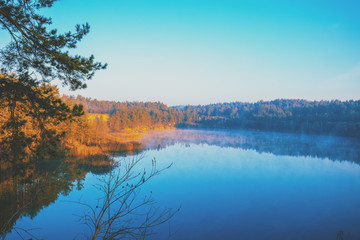 Fototapeta premium Rocky shore of a mountain lake on a misty autumn morning. Beautiful nature of Norway