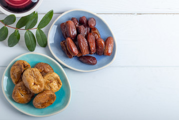 Dried figs and dates on a platter on a white background