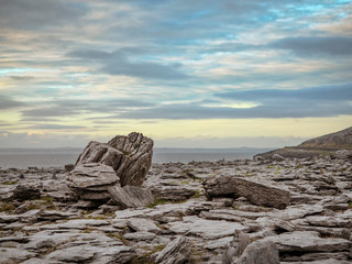 Rough terrain  West coast of Ireland Burren region. Stone plateau by Atlantic ocean, Wild Atlantic way.  Blue cloudy sky. 