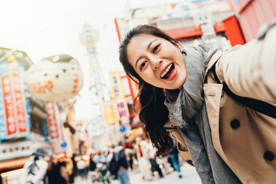 traveler cheerfully taking selfie in tsutenkaku