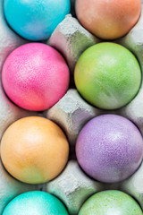 Multicolored easter eggs in a box. Colorful background texture