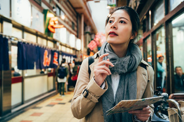 woman holding map guidebook searching for place.