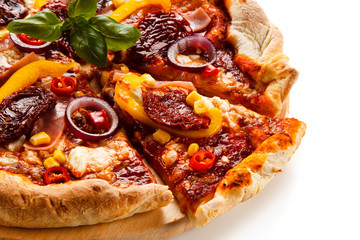 Pizza with ham, corn, mushrooms and dried tomatoes on white background