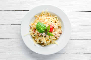 Pasta with bacon and cherry tomatoes. Italian dish. Free space for your text. Top view.