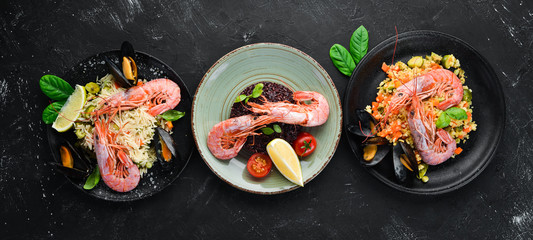 A set of seafood dishes on a black background. Pasta, bulgur, rice, couscous. Top view. Free space for your text.