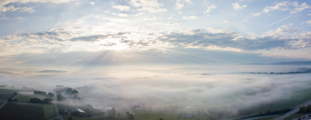 Morning mist over countryside - Aerial view from Drone flight with sunrise at the background