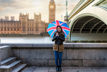 Obraz premium Atrakcyjny turysta z Brytyjską flaga na parasolowym stojaku przed Big Ben w Westminster, Londyn