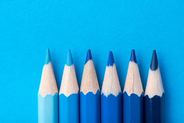 Macro photograph of several pencils of blue color on a paper background