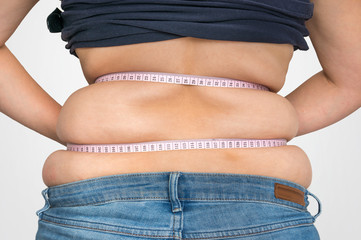 Overweight woman with tape is measuring fat on belly