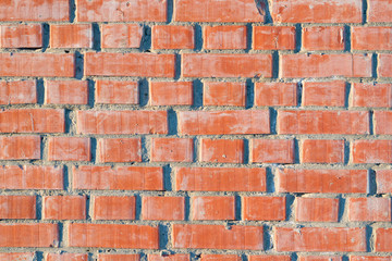 Fototapeta premium Wall surface texture of orange-brown bricks in frost, close-up, abstract grunge background 