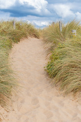 French landscape - Bretagne. Small path with dunes and grass in the foreground.