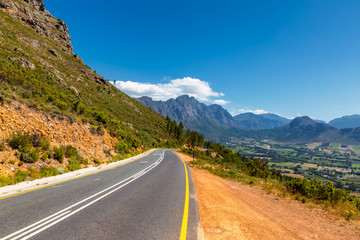 Scenic road at Franschhoek valley with its famous wineries and surrounding mountains, South Africa