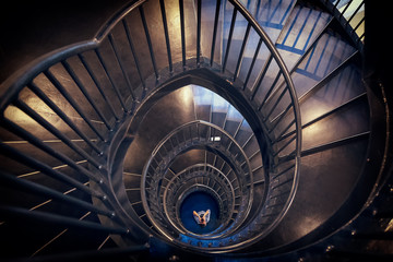 Spiral staircase top view with a photographer staying downstairs