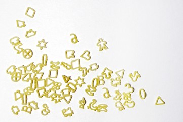 A pile of letters and shapes in the form of pasta, pasta on a light background, space for text