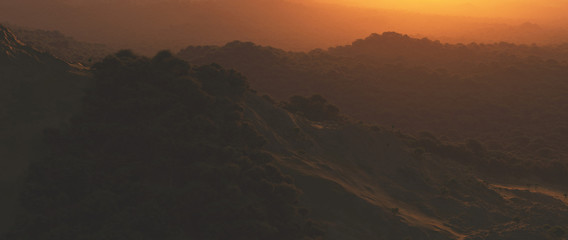Bushy mountains at hazy sunset