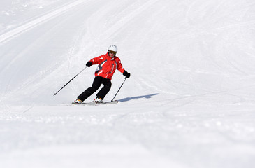 Skier skiing downhill during sunny day in high mountains. Italy, Europe.