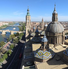 A landscape of Zaragoza with the Puente de Piedra and Puente de Hierro bridges, the Ebro river and a Pilar Cathedral bell tower, in Aragon, Spain