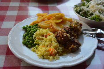 The plate with peas, rice, meat and carrots
