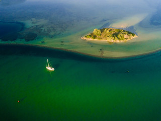 A sailboat anchored near a small island on the south coast of New South Wales,  Australia - 241398754