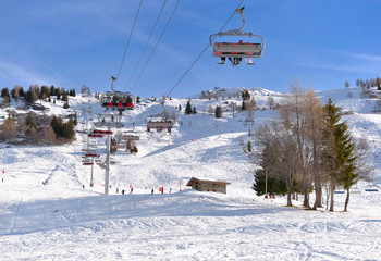 ski lift under blue sky and above ski slope in french alps