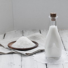 Coconut milk in a vintage bottle on rustic wooden background.