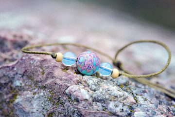 Fashionable stone beads bracelet on rocky background
