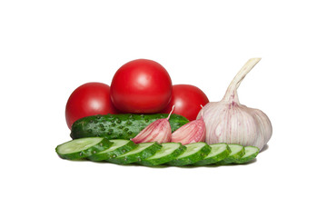 Three juicy red tomatoes, one whole cucumber and one sliced, slices of garlic and a head of garlic isolated on white