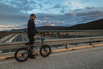 BMX rider with his bmx bike on the street. Guy riding in bmx