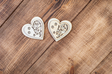 Two wood heart on a vintage wooden background.