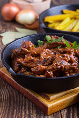 Beef Stroganoff with tomato sauce and sour cream and fried potato